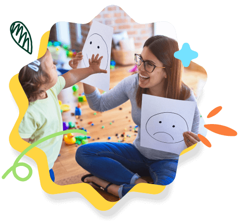 The image shows an adult and a child playfully holding up drawings of facial expressions, surrounded by colorful toys and whimsical doodles.